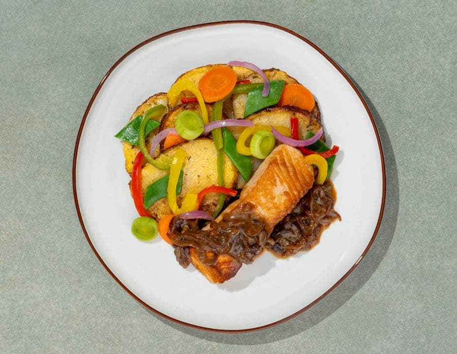 Salmón con salsa encebollada, patatas y verduras variadas